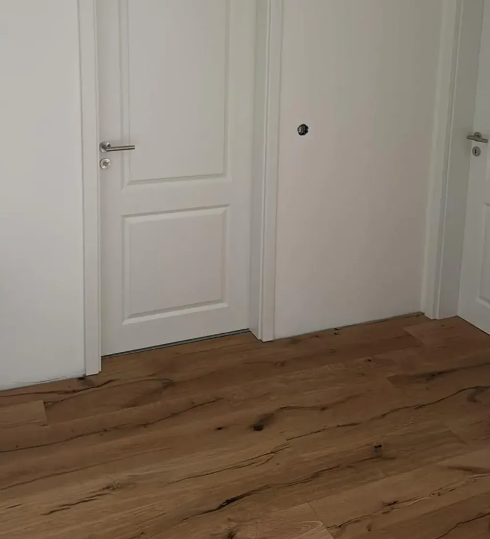 Ausbau Riesenfeldstraße 34 – fertiger Flur mit Parkett und Weißlacktür
